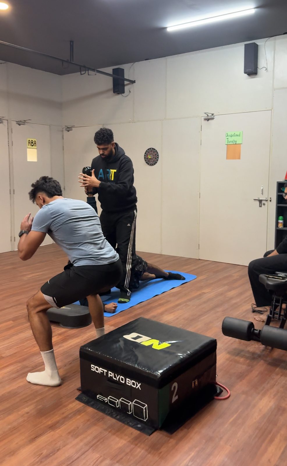 Coach supervising an athlete's plyometric box jump