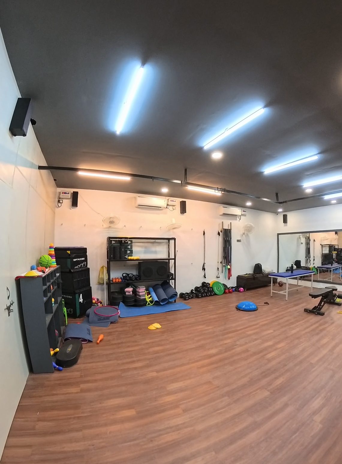 Wall of rehab equipment at ART including dumbbells, bands and plyo boxes