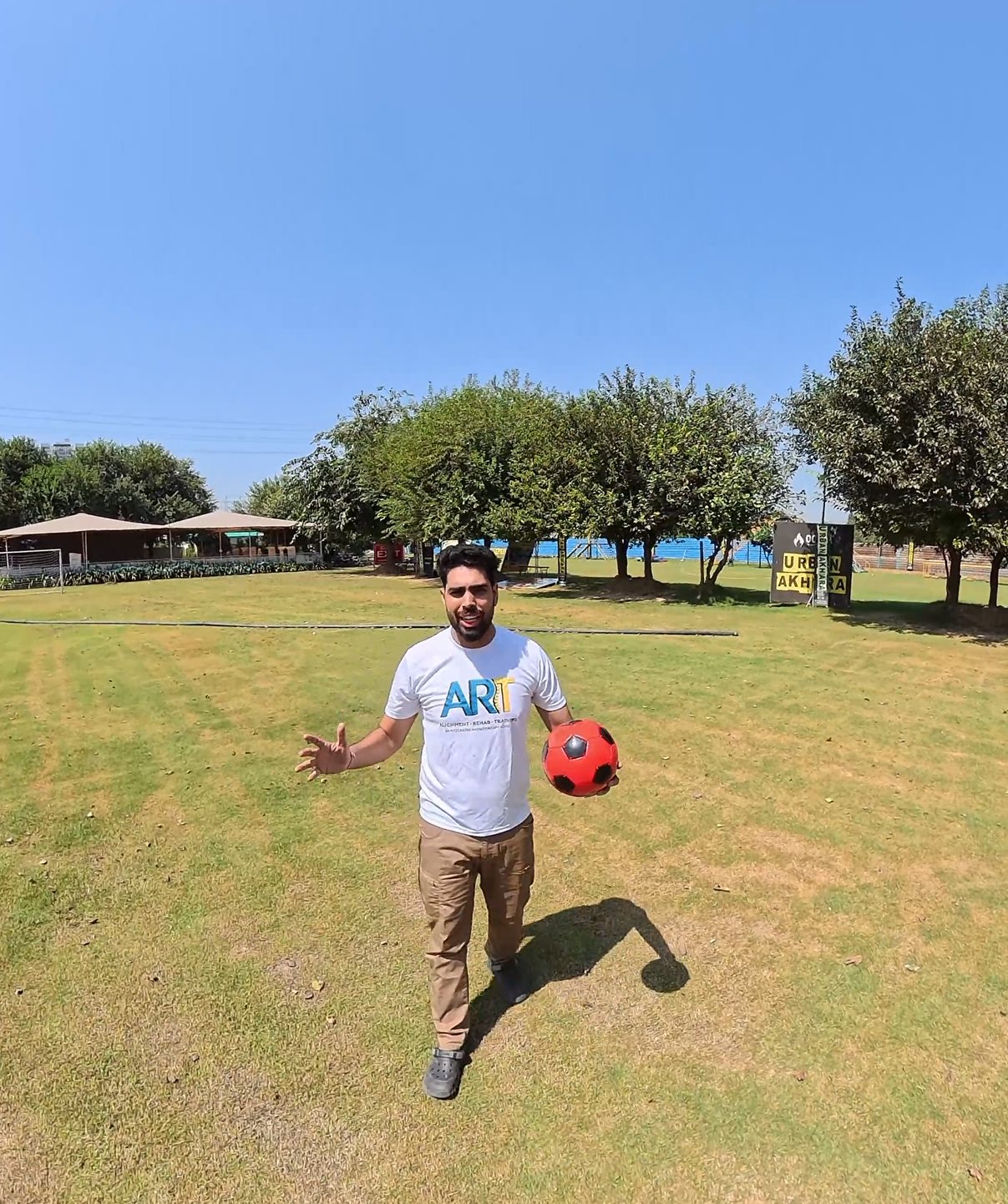 ART coach on the open field with a football for return-to-sport training