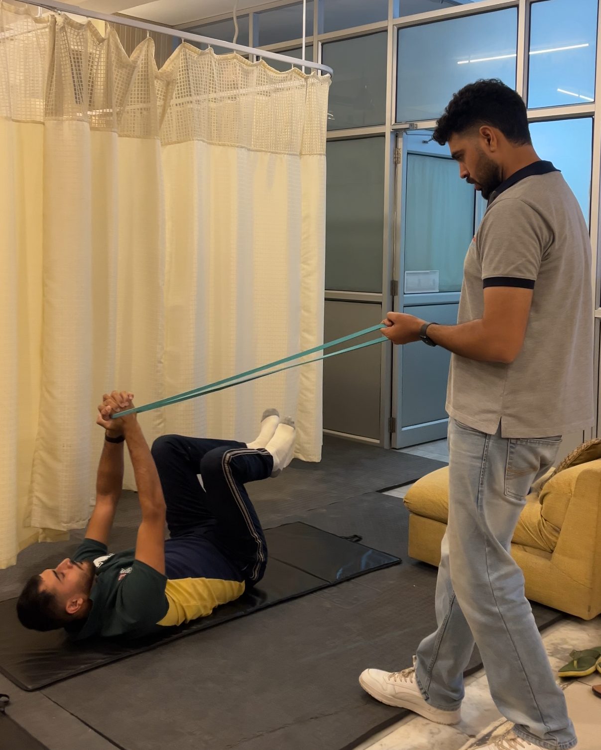 Patient doing band-resisted core and leg work with a therapist